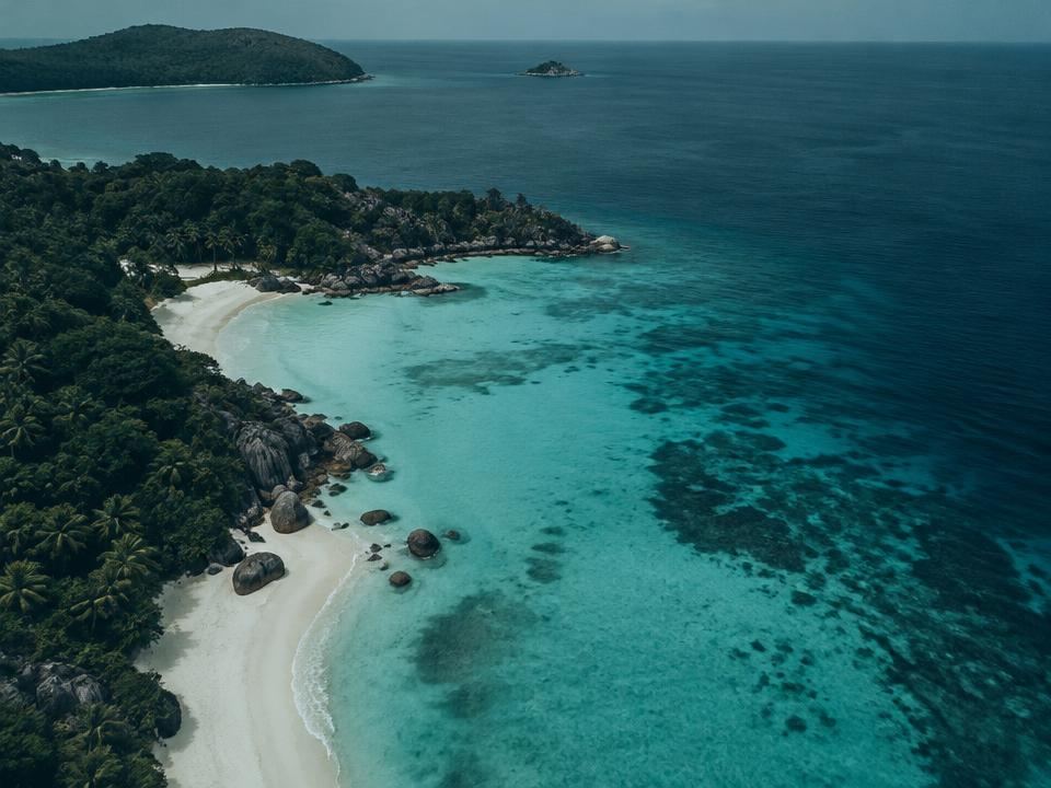 Aerial view of a tropical coastline with turquoise water and a white-sand beach