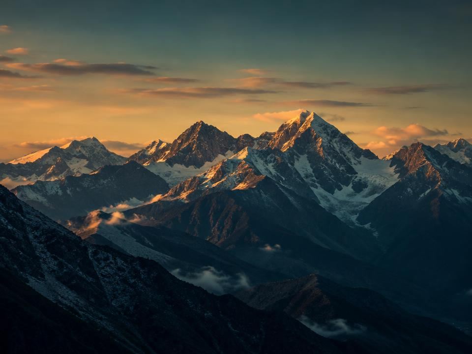 Snow-capped mountain range lit by golden-hour sunlight